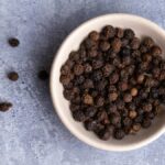 black pepper peppercorns in a bowl for piperine weight loss